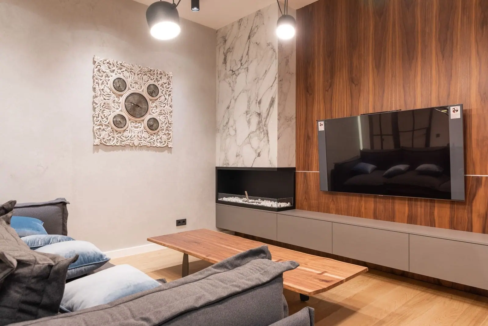 Living room TV wall with walnut panelling, marble accent and a long low storage unit